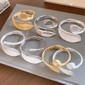 Macro view of heavy industry metallic twisted hollow bracelets in gold and silver finishes