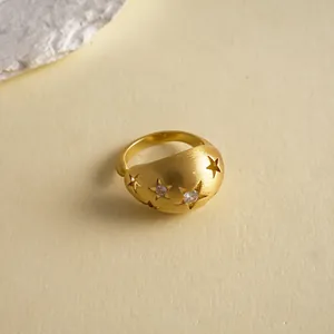 Nahaufnahme eines eleganten mattgoldenen offenen Rings mit Sternausschnitten und Zirkonia