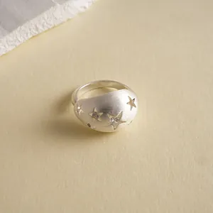 Makroaufnahme eines gebürsteten Silbersternrings mit funkelnden Zirkonia-Steinen.