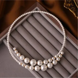 Detailed macro view of a French vintage irregular crossover pearl necklace on grey velvet