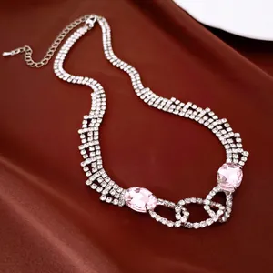 Close-up of pink oval crystals and strands of clear rhinestones on an elegant silver necklace