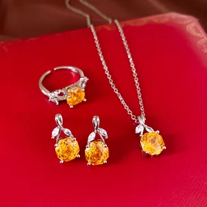 Close-up van elegante zilveren zirkoon sieradenset met gele edelstenen op rode achtergrond