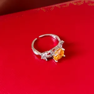Gedetailleerd macro-aanzicht van een elegante zilveren open ring met een gele zirkoon