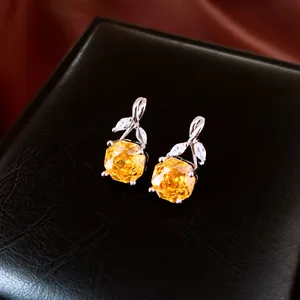 Macro-opname van elegante gele bloem zirkoon oorbellen op een luxe zwarte doos.