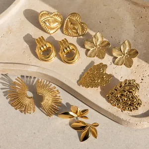 Detailansicht verschiedener goldener Edelstahlohrringe mit bösem Auge und Herzen