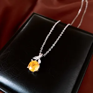 Detail van een elegante ketting met een gele edelsteen hanger op een zwarte doos