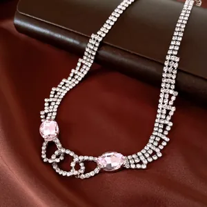 Detail view of a luxury rhinestone necklace featuring large pink oval crystal pendants