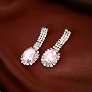 Close-up of elegant pink oval crystal drop earrings with sparkling rhinestone border
