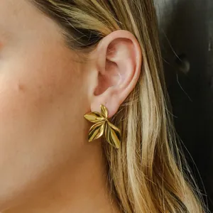 Detaillierte Seitenansicht von goldfarbenen Blatt-Ohrsteckern aus Edelstahl an einem Modelohr