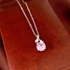 Nahaufnahme der Halskette mit rosa Zirkonia-Blumenanhänger auf braunem Leder.