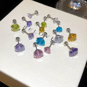 Détail macro de boucles d'oreilles en zircon coloré avec fermoir à vis sécurisé