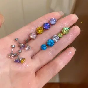Vue détaillée macro de boucles d'oreilles en zircon étincelant avec fermoir à vis sur une main