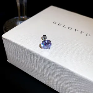 Gros plan d'une boucle d'oreille en zircone lavande avec fermoir à vis sur boîte