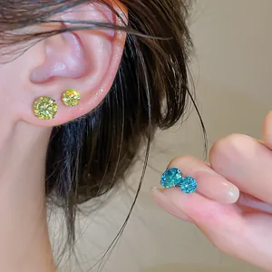 Détail de boucles d'oreilles scintillantes en zircone bleue et jaune avec tiges en argent