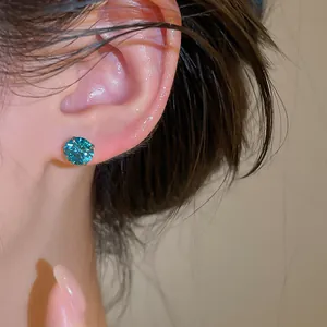 Gros plan d'une boucle d'oreille en zircon sarcelle avec aiguille en argent