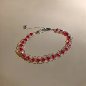 Vista dettagliata di un bracciale vintage con perle di vetro rosse e maglia d'argento.