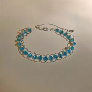 Dettaglio di un bracciale vintage francese con perline di vetro blu e maglia a rete