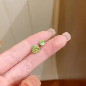 Gros plan détaillé sur des boucles d'oreilles en zircone vert clair étincelant avec tiges en argent