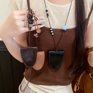 Vue détaillée de colliers étuis à clés en cuir élégants avec perles portés par un modèle