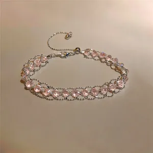 Dettaglio delle perle in vetro rosa su un delicato bracciale a maglia argento