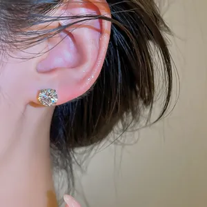 Vue rapprochée d'une boucle d'oreille en zircone cubique étincelante sur l'oreille d'un mannequin