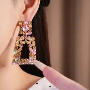 Detailopname van vintage koninklijke vierkante holle oorbellen met strass-stenen