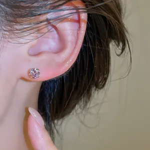 Vue détaillée d'une boucle d'oreille en zircone ronde étincelante sur le lobe de l'oreille