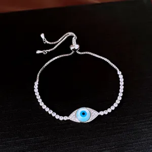 Détail macro d'un bracelet réglable en argent orné d'un œil maléfique pavé de zircons.