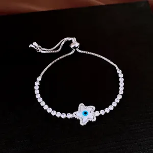 Détail d'un bracelet coulissant en argent avec breloque étoile œil grec et zircons