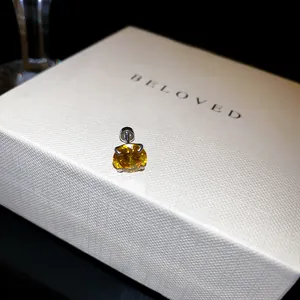 Gros plan d'une boucle d'oreille à vis avec zircone jaune étincelante sur boîte