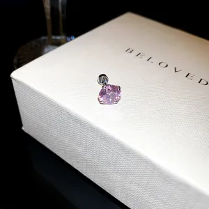 Vue détaillée d'une boucle d'oreille en zircone rose avec fermoir à vis sur boîte.
