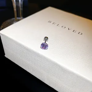 Vue détaillée d'une boucle d'oreille en zircone violette avec fermoir à vis sécurisé