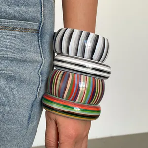 Close-up of vintage resin striped bangles in monochrome and rainbow geometric patterns
