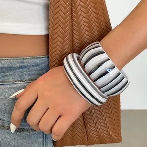 Detailed view of two retro resin bangles with gray and white striped patterns