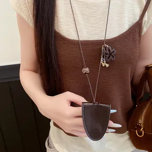 Gros plan d'un élégant collier porte-clés en cuir marron porté par un mannequin féminin