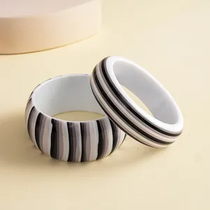 Detail view of retro black and grey striped resin bangles with a glossy finish