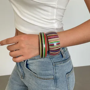 Detailed view of vintage resin striped bangles worn on a wrist for a stylish look.