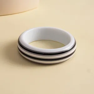 Detailed macro view of a retro resin striped bangle with black and grey geometric lines