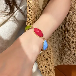 Detail of colorful oval resin stones on a gold-toned vintage style bracelet.