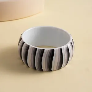 Detailed close-up view of a retro resin chunky bangle with grey and black vertical stripes