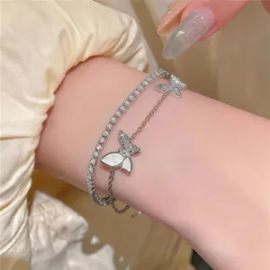 Gedetailleerde macro-opname van een luxe gelaagde armband met vlinderbedels van zirkoon.