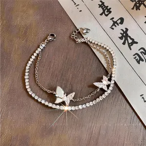 Gedetailleerd overzicht van een elegante dubbellaagse armband met vlinderbedels van zirkoon
