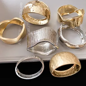 Detail view of various textured metal cuff bracelets in gold and silver finishes