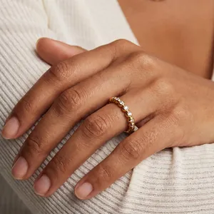 Detailweergave van een 18K vergulde roestvrijstalen ring met zirkonia steentjes aan een vinger