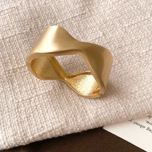 Detailed view of an elegant matte gold metal cuff bracelet featuring a wrinkled design