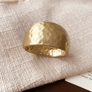 Close-up detail showing the unique matte gold hammered texture of this open cuff bracelet