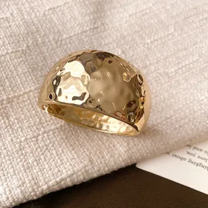 Detailed macro view showing the golden hammered texture and irregular surface of this wide cuff bracelet