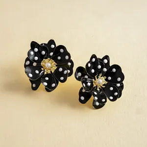 Vue détaillée de boucles d'oreilles fleurs noires à pois blancs et perle