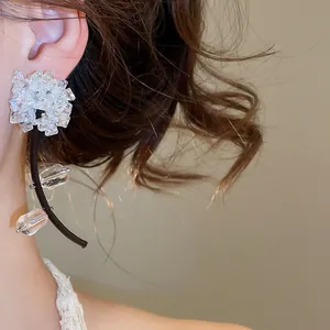 Gros plan d'élégantes boucles d'oreilles à pompons en cristal noir et blanc porté