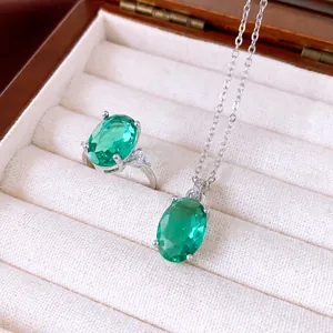 Detailansicht eines ovalen grünen Zirkonia-Rings und einer Halskette in einer Schatulle.